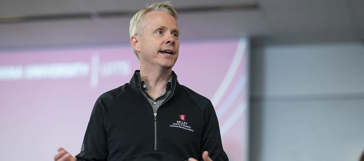 An academy director speaks in front of a classroom